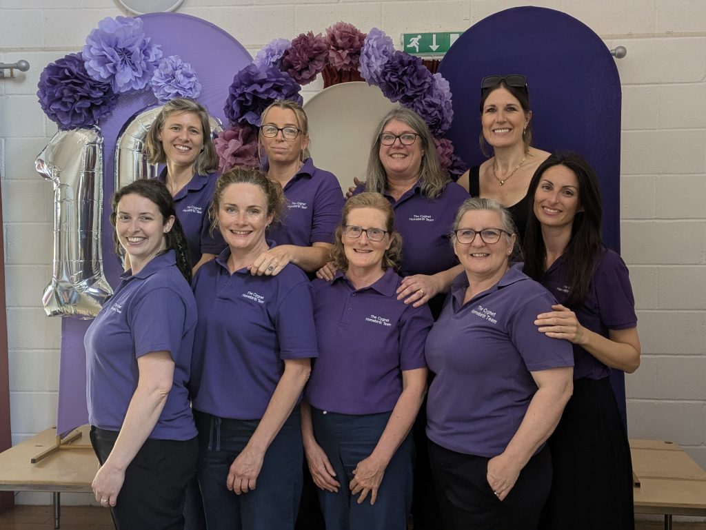 Cygnet Team Staff in purple t shirts in front of a number 10 balloon