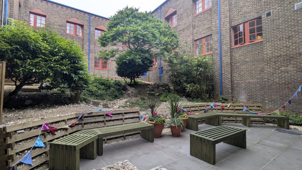 PXL_20250610_083609749 Trees, benches and plants in the hospital courtyard